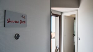 A hallway with a sign reading "Sunrise Suite" and a door leading to another room. - Etna Sunrise B&B (Zafferana Etnea)