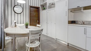 A modern kitchen with white cabinets, a built-in oven, and a stainless steel sink. - Appartamento Capo D'Africa 30 (Rome)