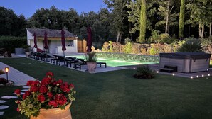 A well-maintained garden with a wooden deck, a hot tub, and a patio area with outdoor furniture. - Chambres d'hôtes La Dryade (Tourves)