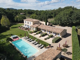 Uma grande villa com piscina, área de estar ao ar livre e um jardim bem cuidado.