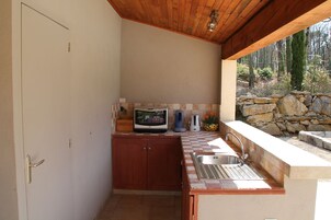 Uma cozinha compacta com bancada de pedra, pia embutida e armários de madeira.