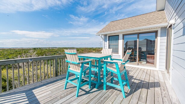 A wooden deck with turquoise chairs and a table, overlooking a coastal landscape. - Simply Perfect - S Nags Head MP 19.5, 120 Yds to Beach, Ocean View, Community Pool, Tennis (South Nags Head)