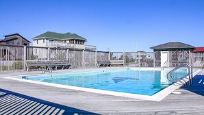 A rectangular swimming pool with a metal ladder on one side, surrounded by a wooden deck and a wooden fence. - Simply Perfect - S Nags Head MP 19.5, 120 Yds to Beach, Ocean View, Community Pool, Tennis (South Nags Head)