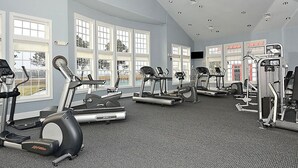 Une salle de sport équipée de tapis de course, de vélos elliptiques et d'appareils de musculation.