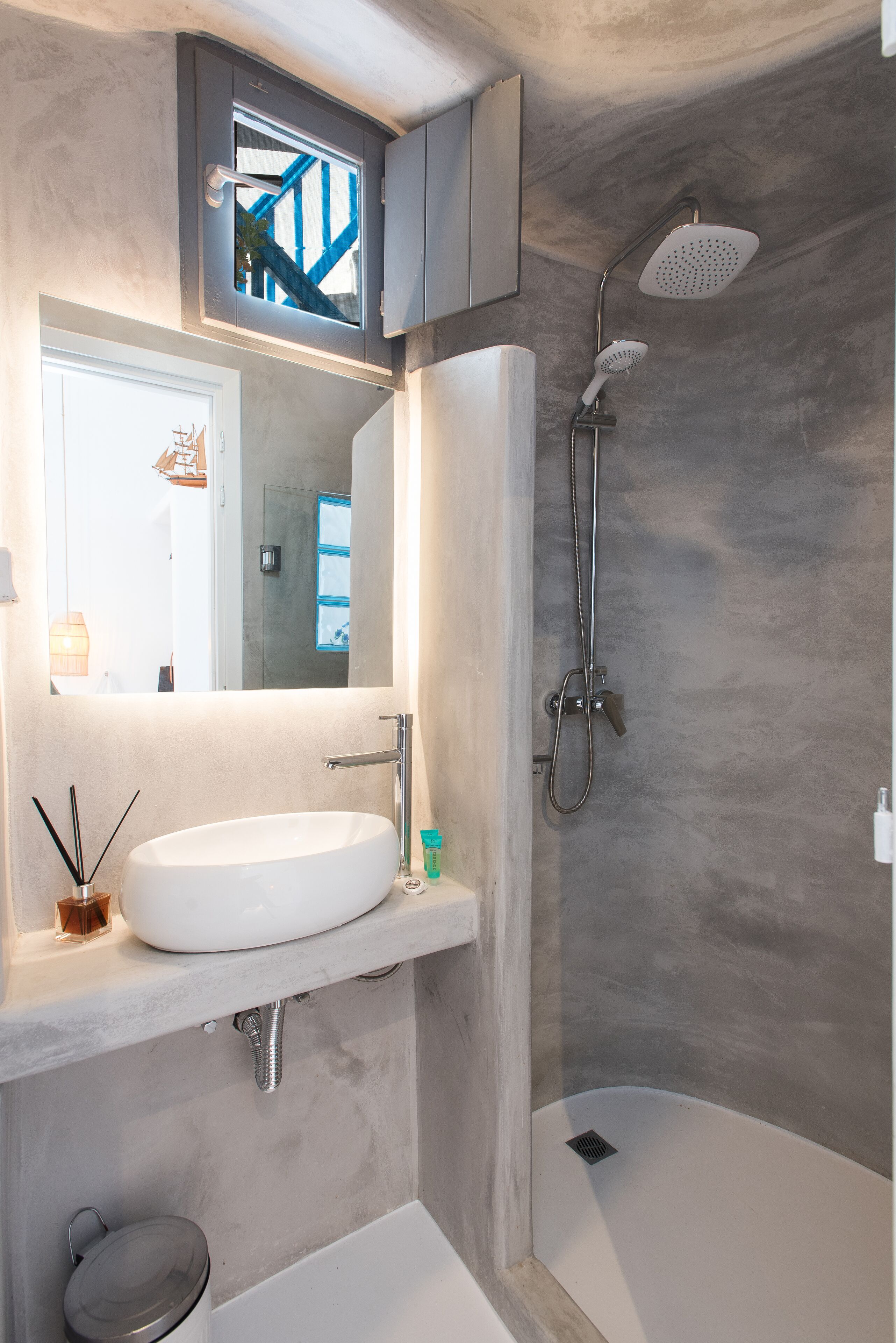 Ein modernes Badezimmer mit einem großen Waschbecken, einer Dusche und einem Spiegel über dem Waschbecken.