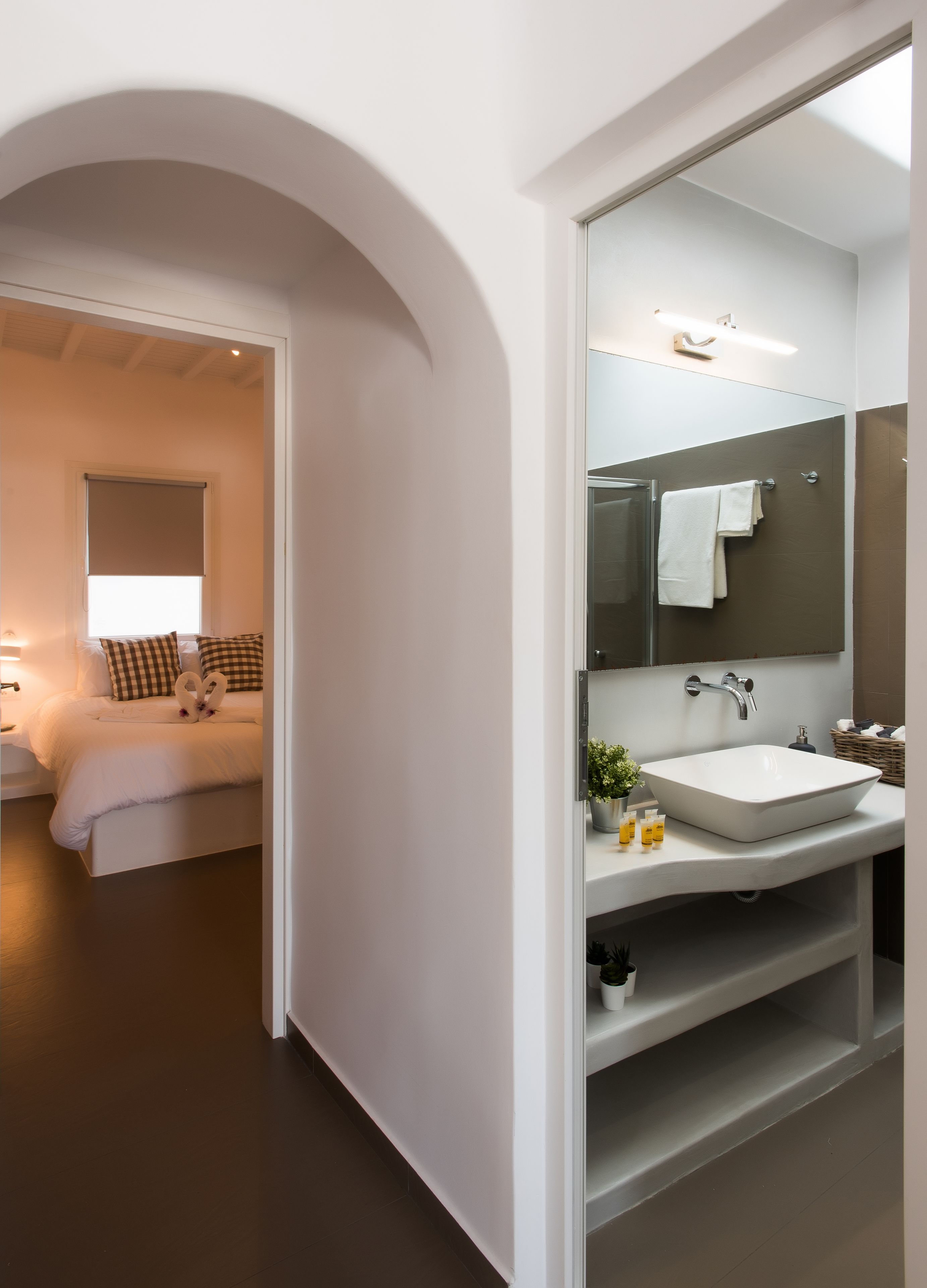 Un baño moderno con un espejo grande, un lavabo blanco y una zona de ducha.