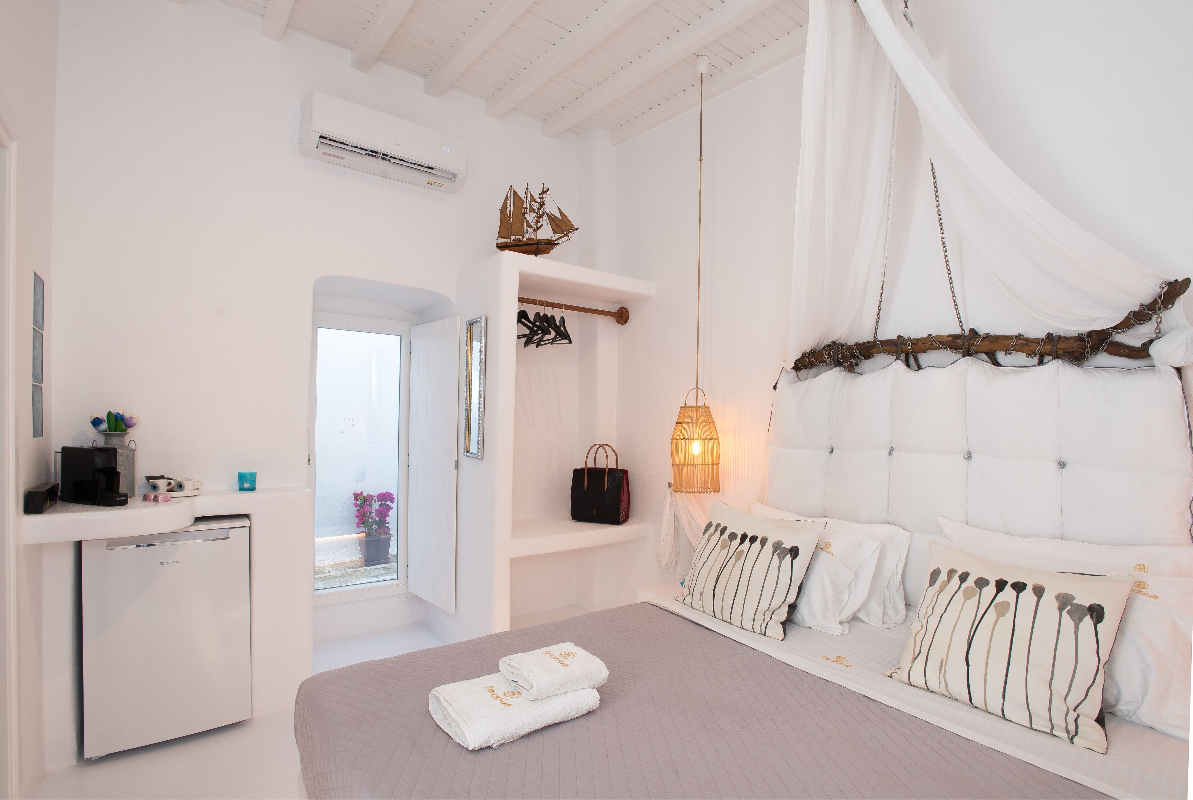 A bedroom with a bed, bedside table, and a hanging chair.