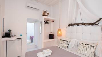 A bedroom with a bed, bedside table, and a hanging chair.
