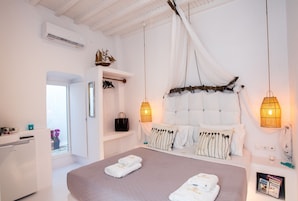 Un dormitorio con una cama grande, lámparas de noche, un armario y una ventana con vistas.