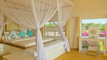 Un dormitorio con cama a dosel, un escritorio con espejo y vistas al verdor exterior.