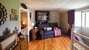 Una sala de estar acogedora con un sofá azul oscuro, suelo de madera y una pared de acento de piedra.