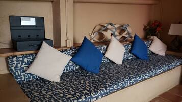 A seating area with patterned cushions, a small table, and a power outlet.