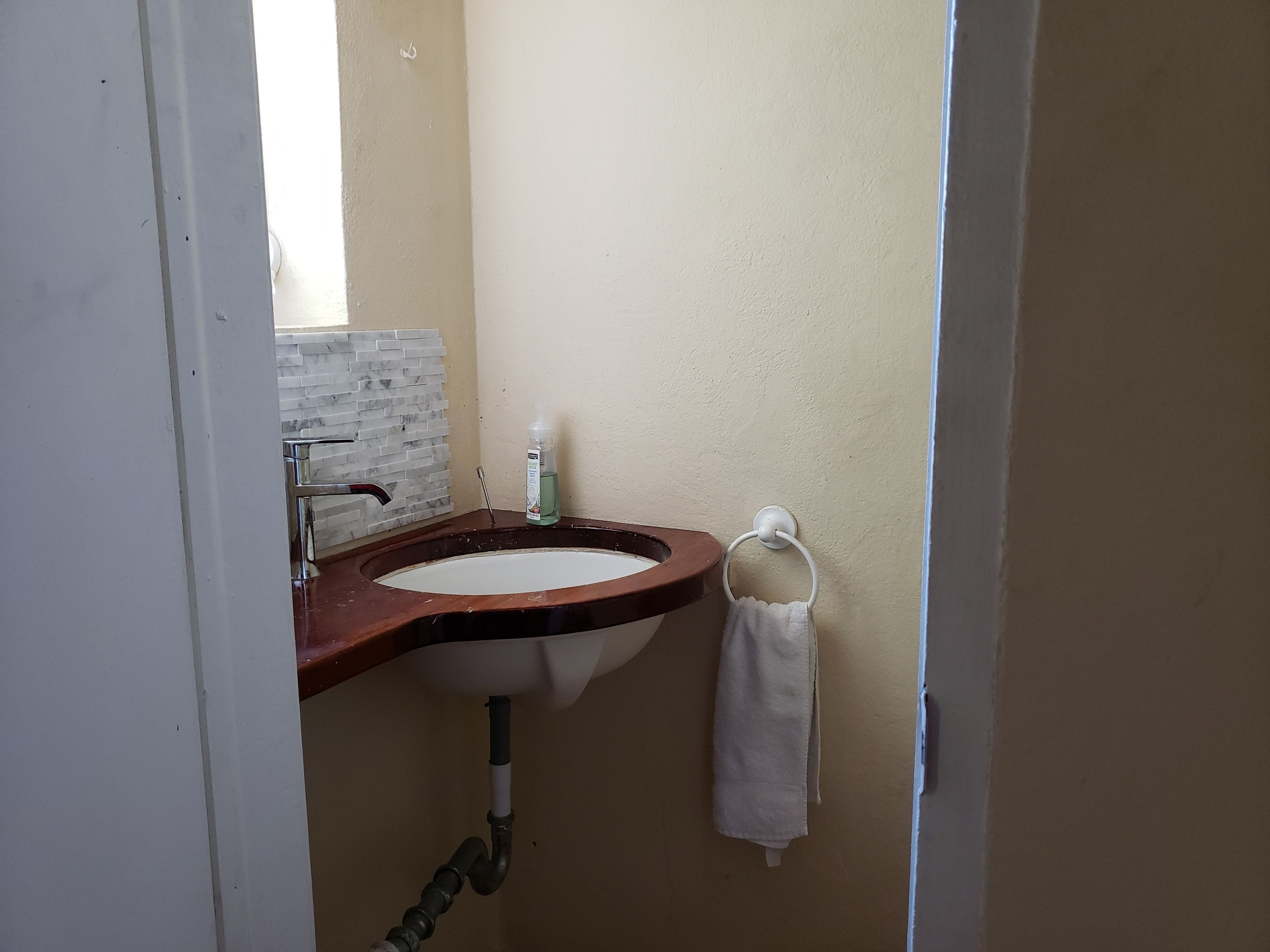 A bathroom with a sink, mirror, and towel rack.