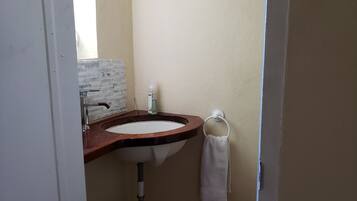 A bathroom with a sink, mirror, and towel rack.