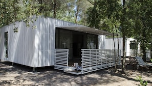 Een moderne, compacte accommodatie met een overdekte veranda en een klein terras.