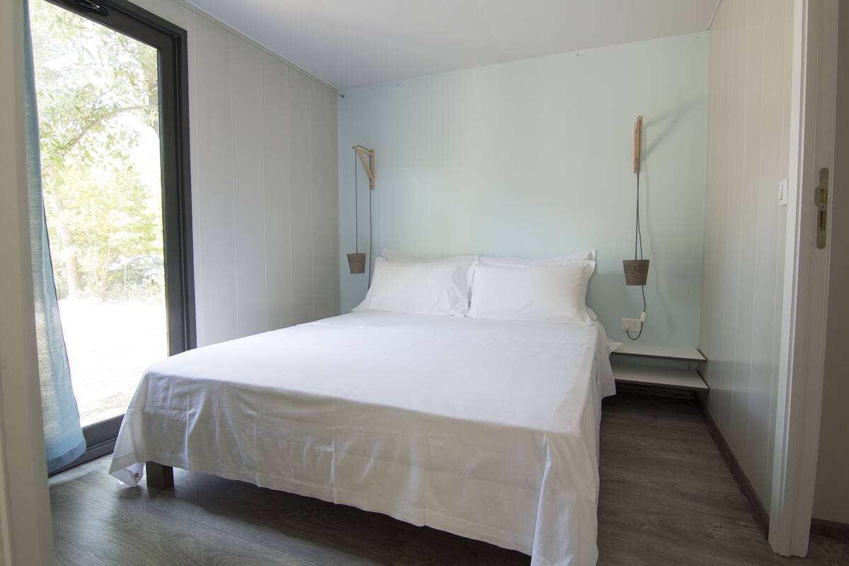 Een slaapkamer met een groot bed, een raam en een deur.