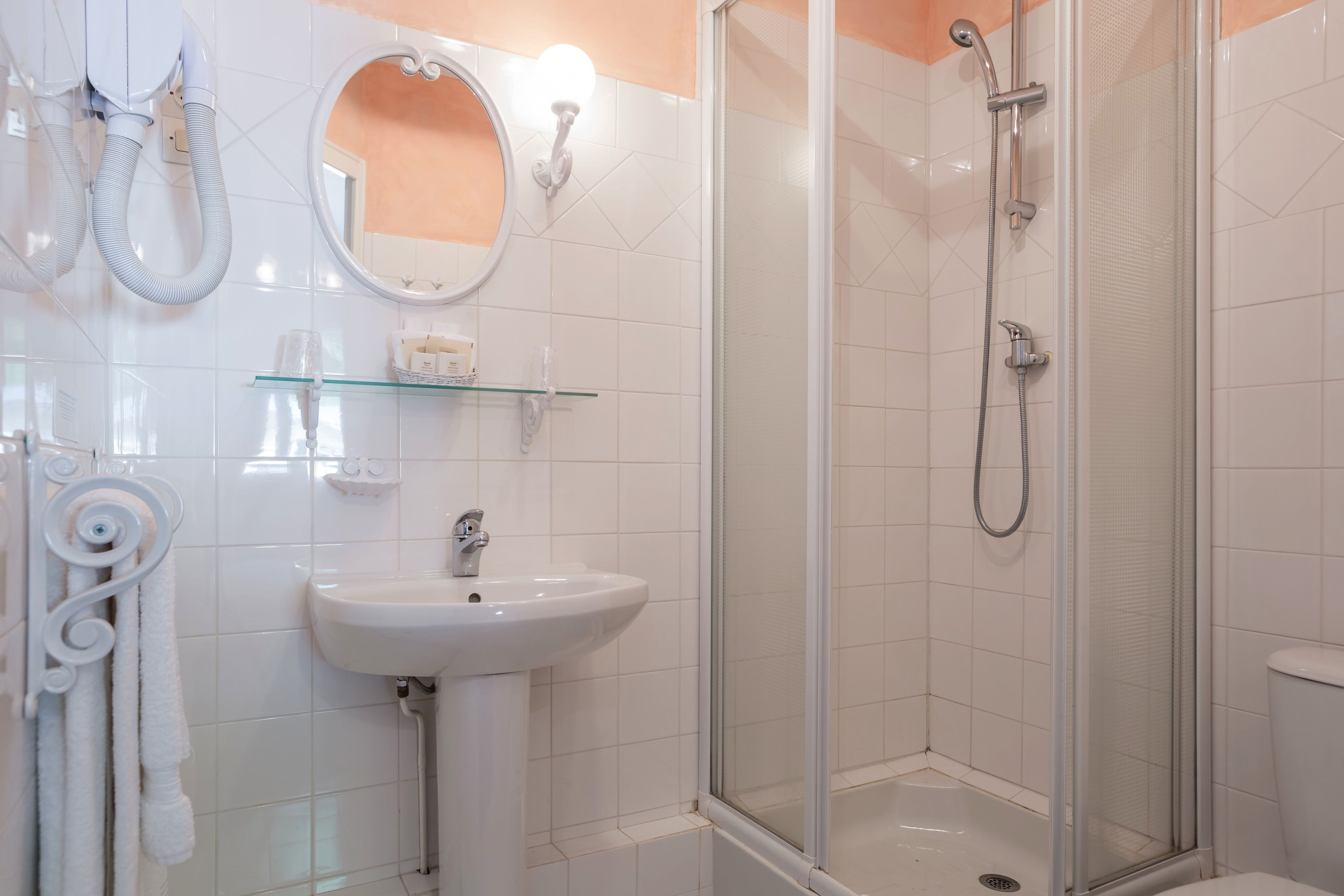 Un baño moderno con cabina de ducha de vidrio, un lavabo blanco y un espejo encima.