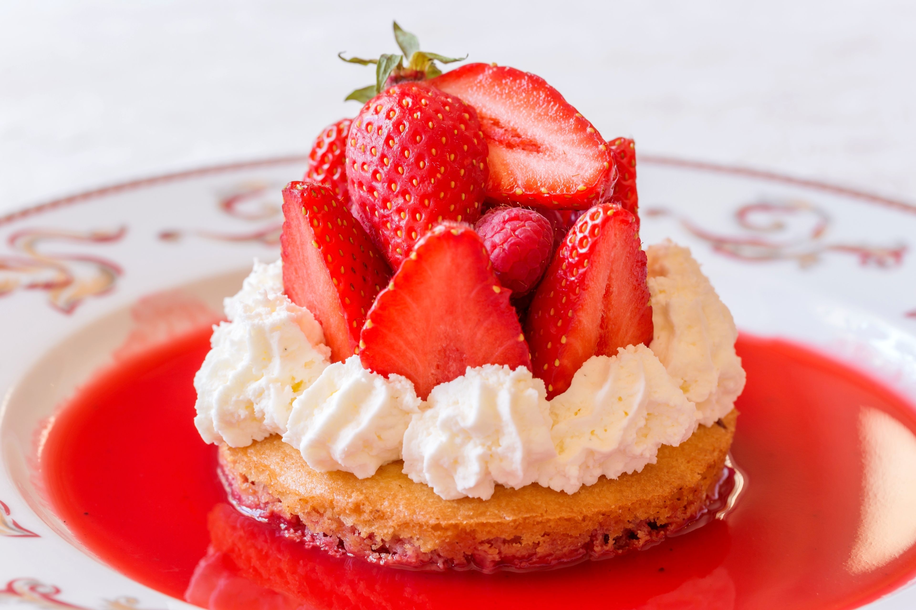 A dessert with strawberries and whipped cream on a plate.