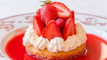 A dessert with strawberries and whipped cream on a plate.