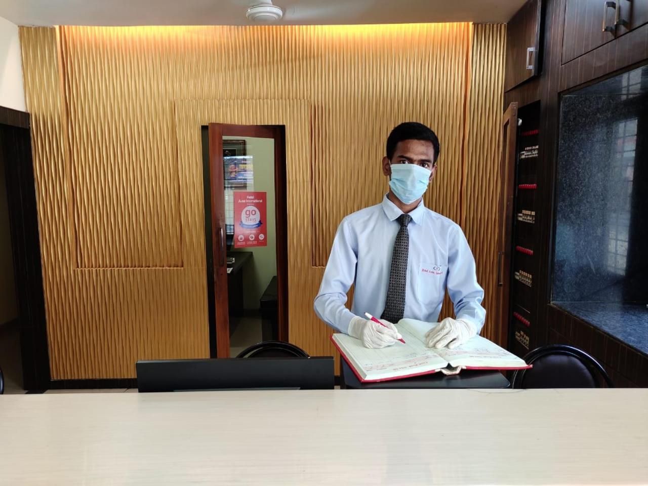 Una recepción de hotel con un panel de pared de madera, un letrero de seguridad contra incendios y una pantalla digital.