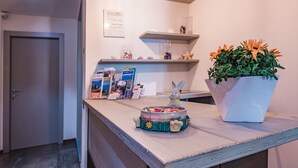 Una reception con una pianta in vaso, un coniglio decorativo e brochure informative.