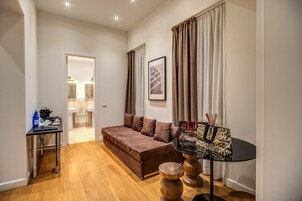A modern living room with a sofa, a small table, and a decorative lamp.