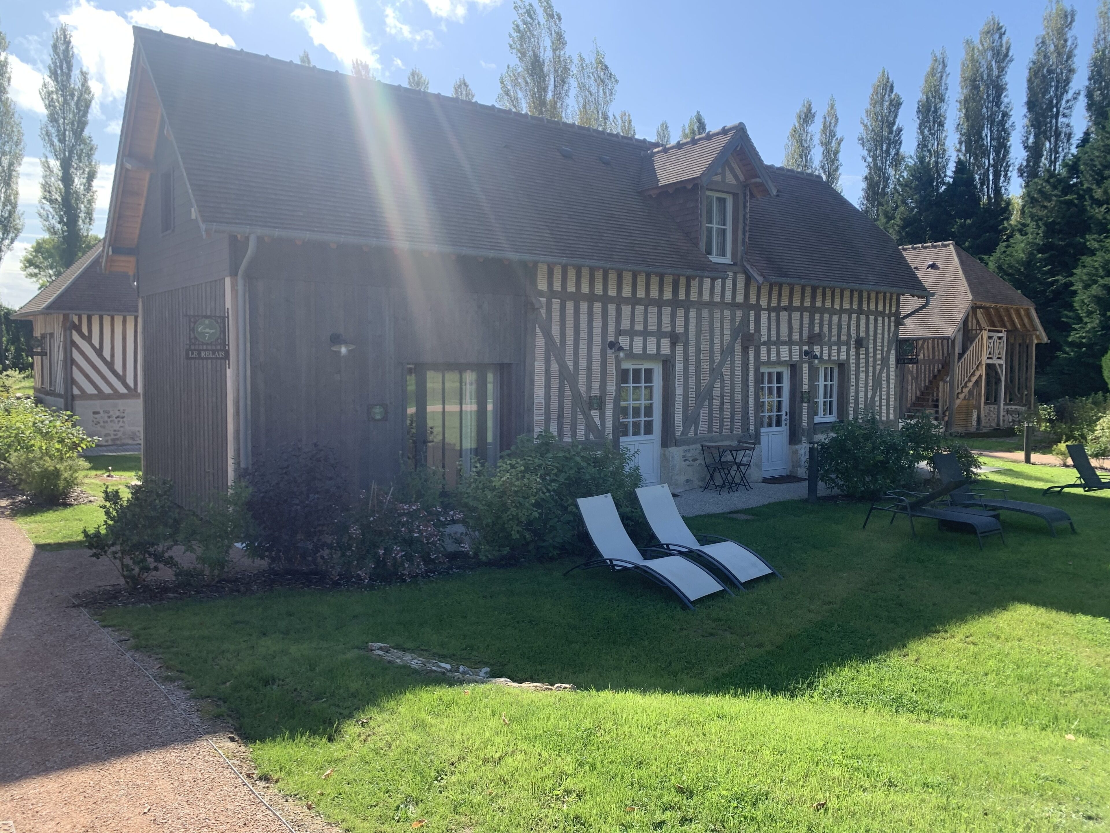 A traditional half-timbered house with a well-maintained lawn and outdoor seating area.