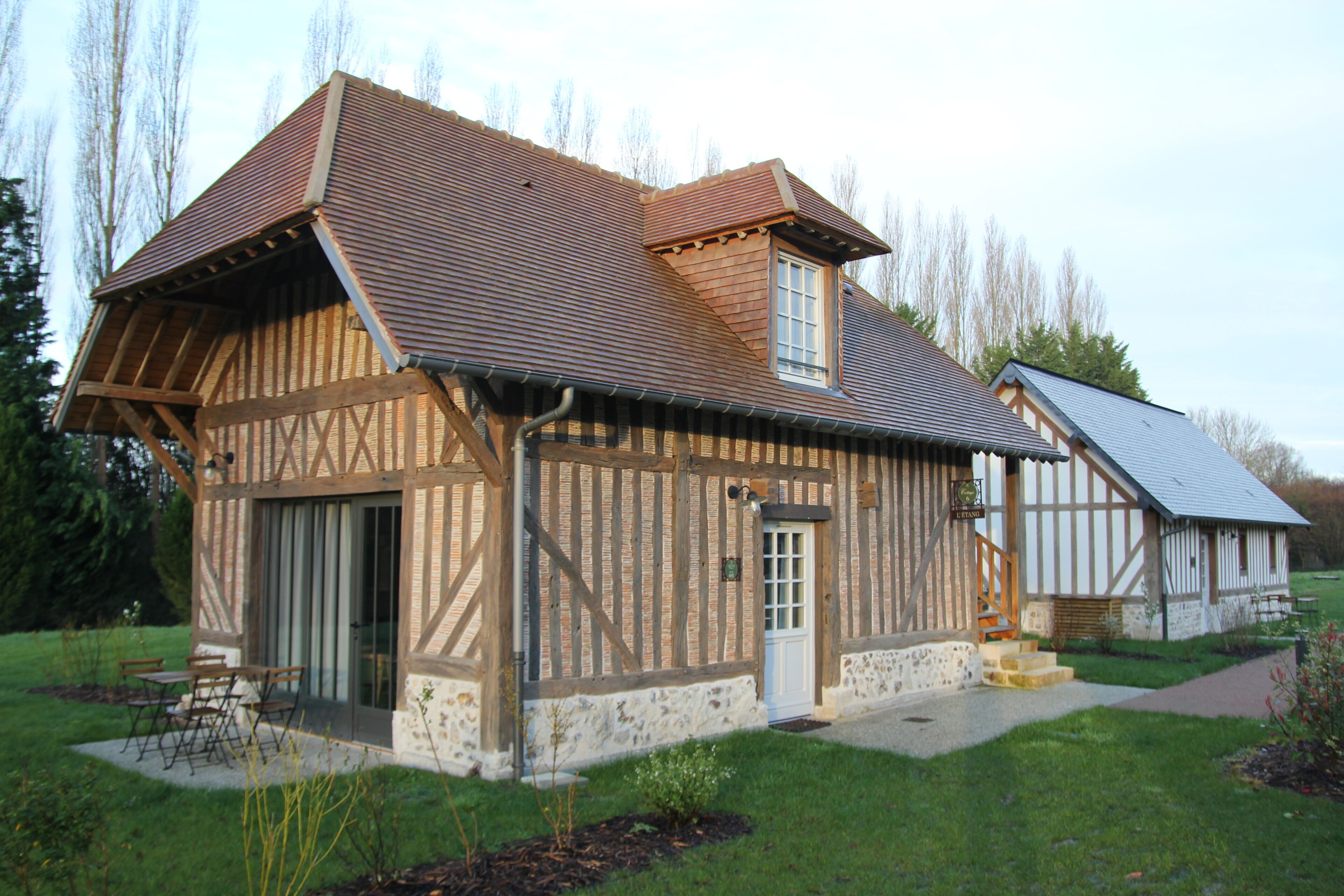 A traditional half-timbered house with a sloped roof, a small porch, and a visible staircase leading to the entrance.