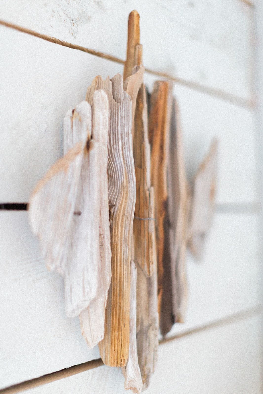 Una pared de madera con pinzas de ropa sujetando trozos de tela.