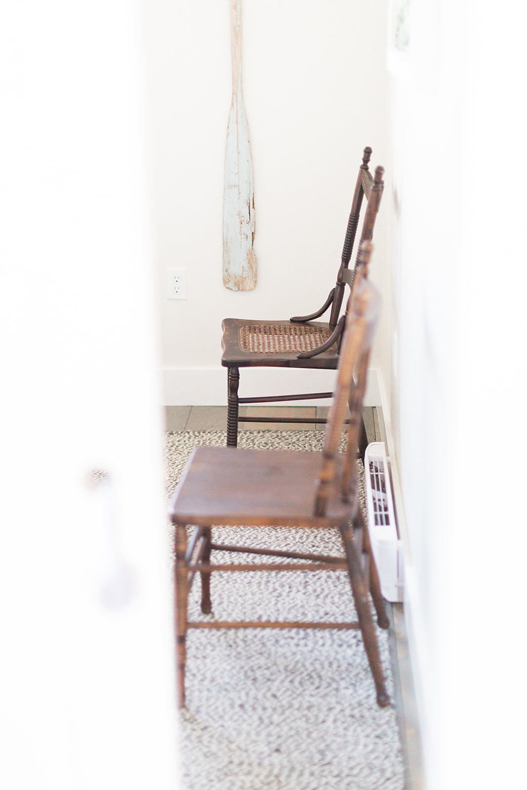 A room with a wooden bench and a white wall.