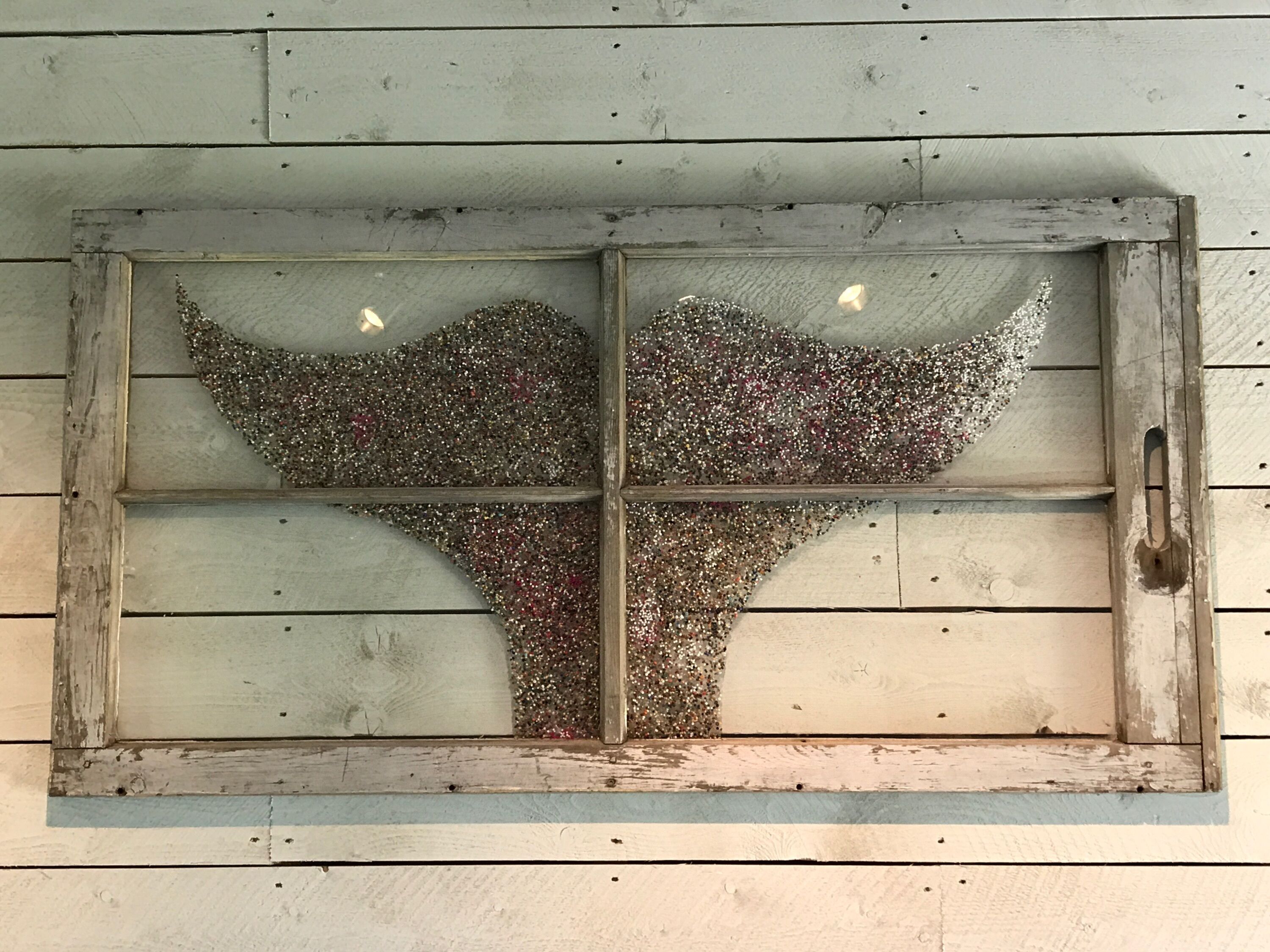 A rustic wooden window with a decorative glass panel featuring a tree silhouette.