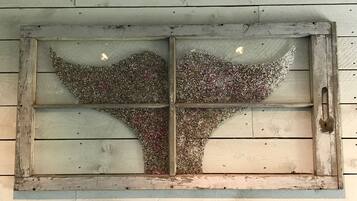 A rustic wooden window with a decorative glass panel featuring a tree silhouette.