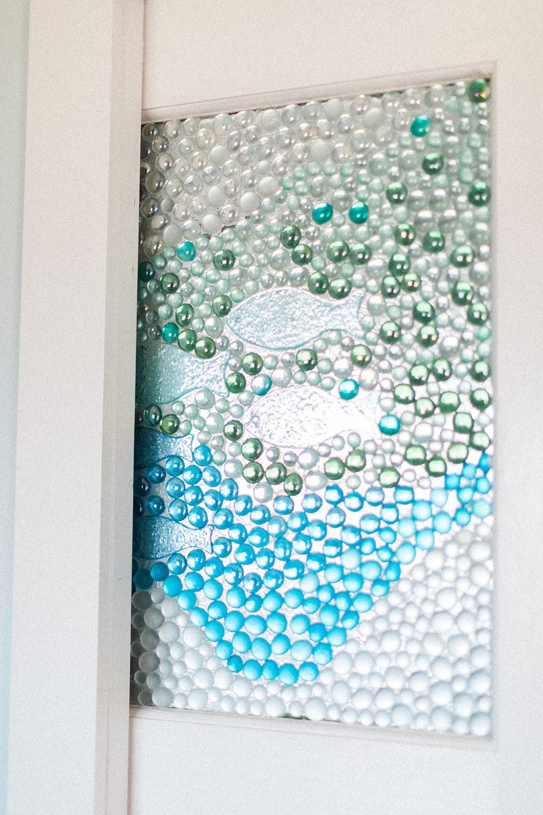 A frosted glass window with a decorative pattern.