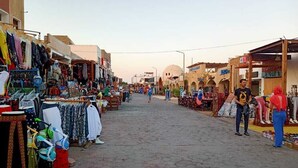Een levendige straatmarkt met verschillende kraampjes die kleding en accessoires verkopen.