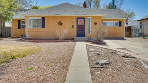 A single-story house with a front yard, a pathway leading to the door, and a small garden area. - Pueblo House by Riverwalk, 2 Miles to Fairgrounds! (Pueblo)