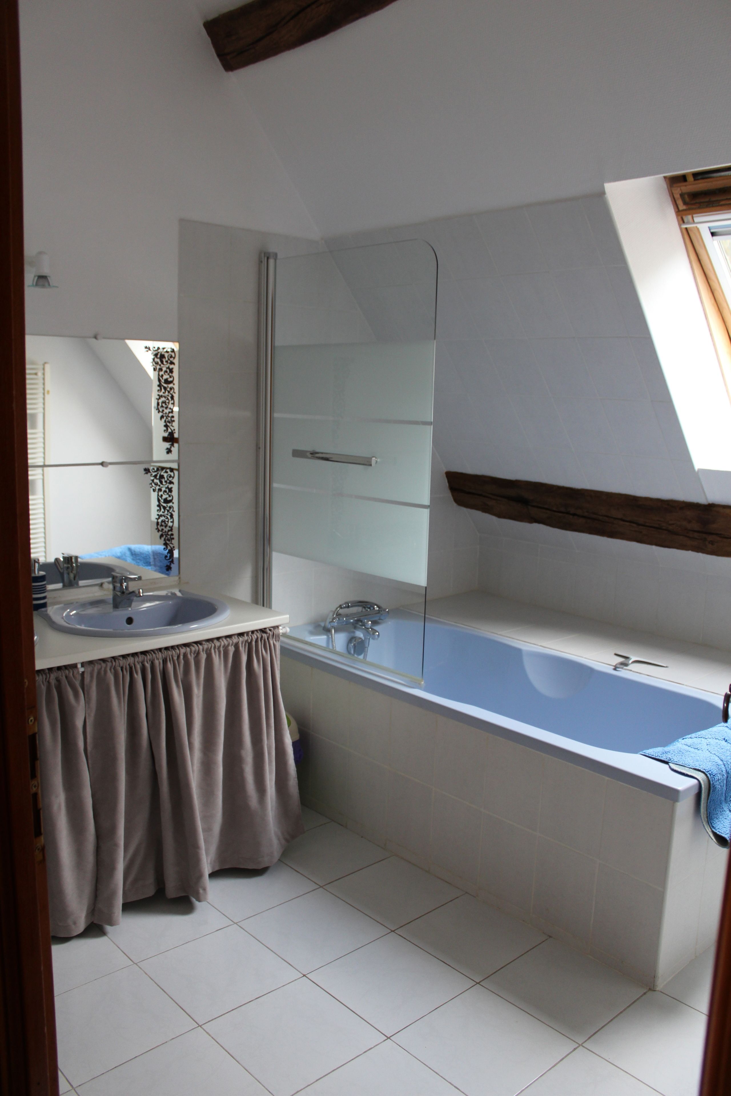 Un baño con lavamanos, espejo y bañera.