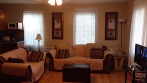 A living room with a sofa set, a television, and a coffee table.