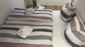Un lit bien fait, avec une literie à rayures et des serviettes pliées.