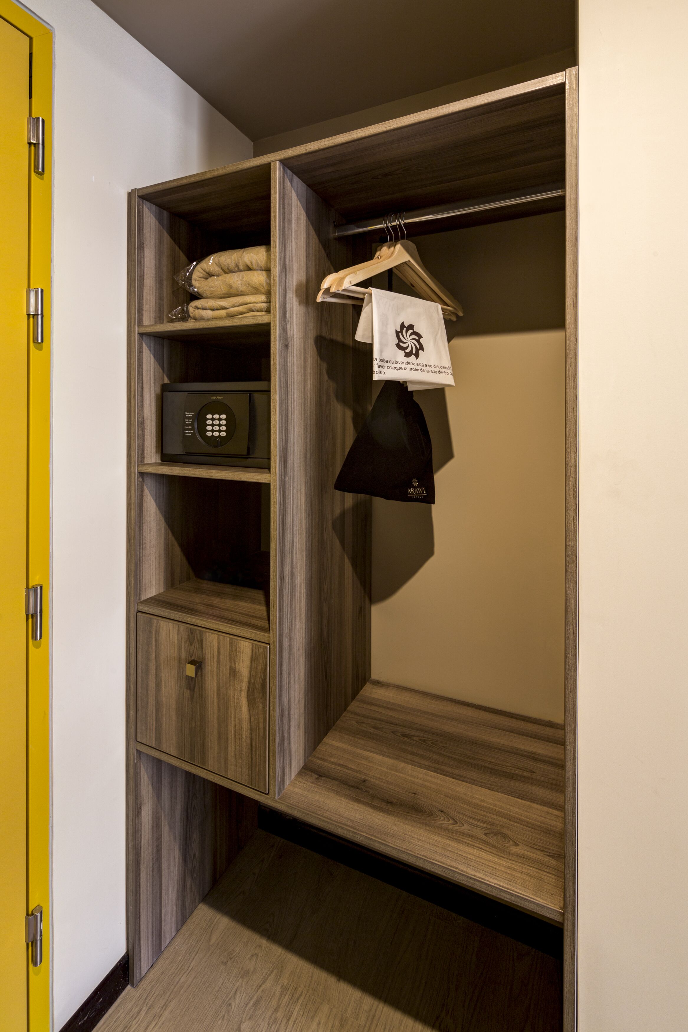 Un vestidor con estantes de madera, una percha y una caja fuerte.