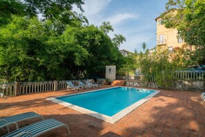 Relax by the serene pool surrounded by lush greenery and a tranquil atmosphere.