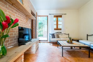 Relax in this open-plan living area with a flat-screen TV, wooden bench, and comfortable sofa.
