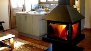 Una sala de estar acogedora con chimenea, comedor y cocina con una isla grande.