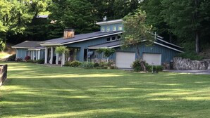 A two-story house with a garage, surrounded by a well-maintained lawn and trees. - Sunset View Estate, a farm setting, upscale house. (Cosby)