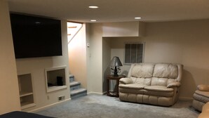 A bedroom with a bed, a TV mounted on the wall, a chair, and a small table with a lamp. - Sunset View Estate, a farm setting, upscale house. (Cosby)