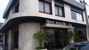 Un hotel moderno con fachada curva, ventanas amplias y un letrero que dice "Hotel Areias Brancas".