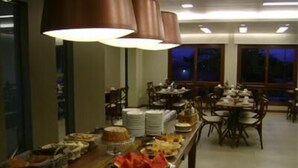 Montaje de bufé con diversos alimentos y una zona de comedor con mesas y sillas.