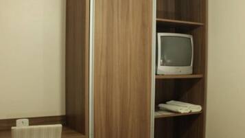 A wooden cabinet with a television on top and a keyboard below.