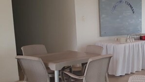 A dining area with a table and chairs, a wall-mounted sign, and a table set with plates and glasses. - Mintaka Hotel  Lounge (Cartagena)