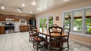 A spacious kitchen with a dining area, featuring wooden cabinets, a large window, and a ceiling fan. - NORRIS LAKE FRONT RENTALS : CAMP RUN A MUK-LAKE FRONT with PRIVATE DOCK (Lafollette)