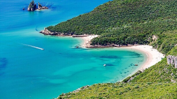 A coastal landscape with a beach, clear turquoise waters, and lush green hills. - Lingon Silver Apartment, Wifi, AC, Balcony (Sesimbra)